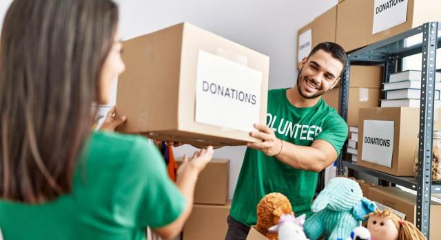 Ejemplo de la adquisición de un activo para donarlo a una entidad sin fines lucrativos (Consulta 2 BOICAC 124). Imagen de pareja sosteniendo una caja de donaciones