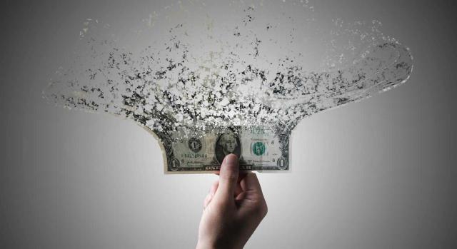 IFRS avanza en la consolidación de subsidiarias y anuncia enmiendas a IAS 21 para entornos hiperinflacionarios. Imagen de un dóllar desintegrandose a cama lenta en partículas