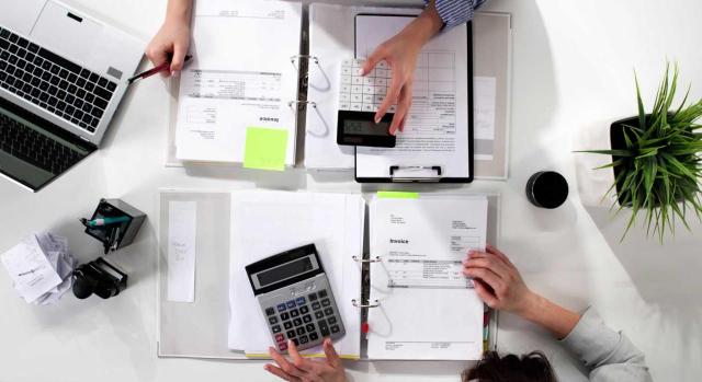 ¿Cómo dominar la contabilidad para ofrecer un asesoramiento fiscal riguroso y eficaz? Imagen de una vista aérea de una mesa de un contable