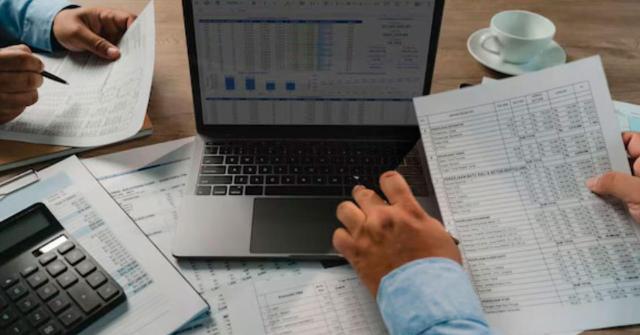 Periodo medio de pago a proveedores: criterio del ICAC Periodo medio de pago a proveedores: el ICAC aclara cómo calcularlo correctamente. Imagen de un escritorio de trabajo lleno de hojas con tablas con el ordenador y la calculadora en la mesa
