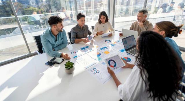 Herramientas clave para el éxito empresarial. Imagen de grupo multirracial de personas que trabajan con Paperwork en una mesa