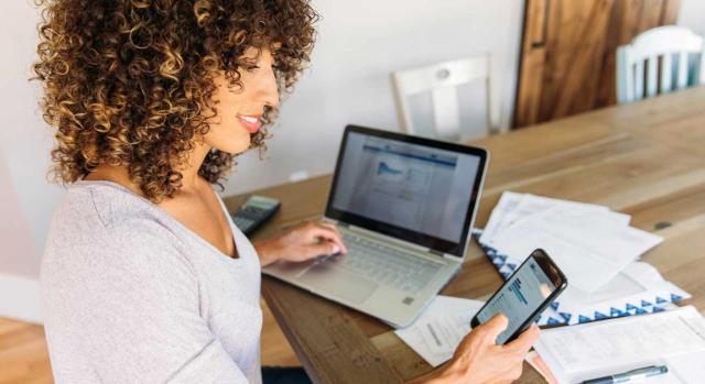 Cómo afectan las decisiones de gestión y financiación a los estados financieros. Imagen de una mujer haciendo sus finanzas en su casa