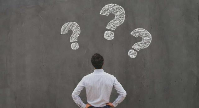 BOICAC 144: El ICAC aclara el tratamiento de permutas de servicios, existencias y el PMP a proveedores. Imagen de un chico de espaldas mirando la pared negra a los signos de interrogación