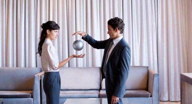 Los buenos contables deben reflejar la imagen fiel de la empresa con su contabilidad. Imagen de mujer y hombre de frente con bola flotando entre sus manos