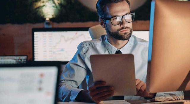 Nueva NIIF 18: La Unión Europea oficializa el cambio en la presentación de estados financieros. Imagen de un joven trabajando con su tablet y el ordenador mirando gráficas