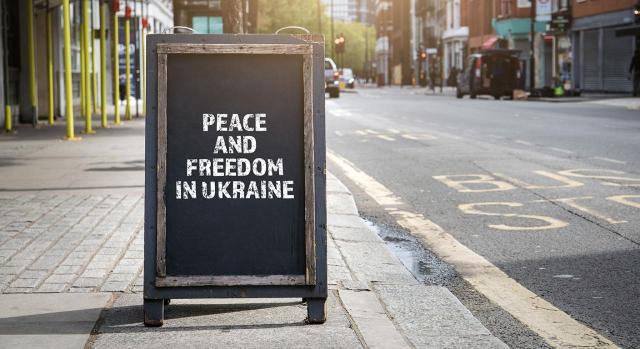 La importancia del principio contable de prudencia y las provisiones en tiempos convulsos. Imagen de un cartel publicitario plegable en la calle donde pone paz y libertad en Ucrania en inglés