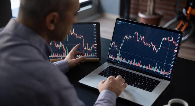 IASB. Revisión de los requisitos de deterioro relacionados con los instrumentos financieros. Un hombre comprobando su inversión en el mercado de valores utilizando su ordenador portátil