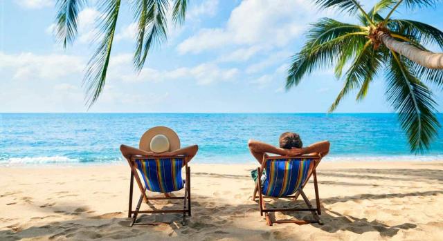 El trabajo del contable y las vacaciones. Imagen de pareja relajándose sentados en hamacas frente al mar